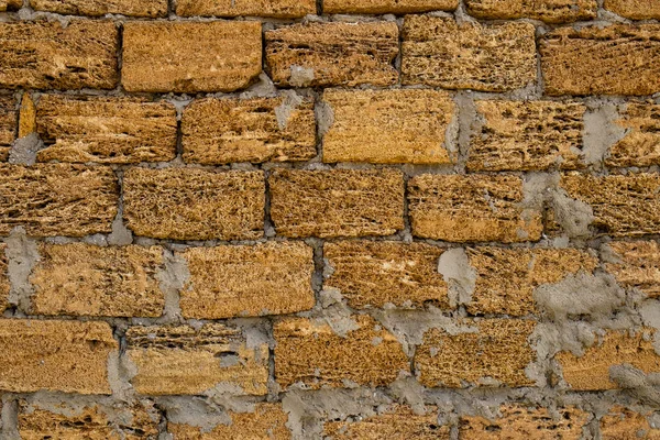 Ziegelmauer aus gelbem Muschelgestein. Nahaufnahme von Muschelsteinen. — Stockfoto