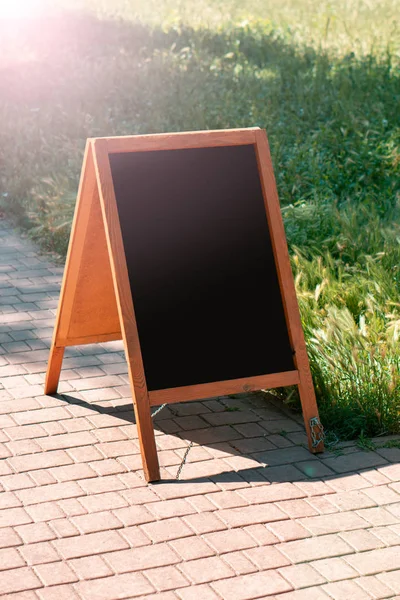 A black chalkboard stand on wood for a restaurant menu in the st