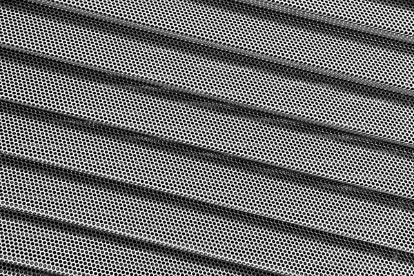 Sfondo di griglia metallica ondulata con fori. Rete metallica come zaino — Foto Stock