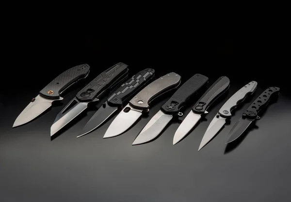 Uma variedade de facas dobráveis modernas em um fundo escuro. Bolso — Fotografia de Stock