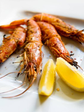 Limonlu kral karidesler. Limon dilimleri ile bir tabak üzerinde Karides.