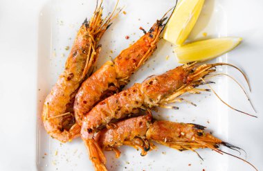 Limonlu kral karidesler. Limon dilimleri ile bir tabak üzerinde Karides.