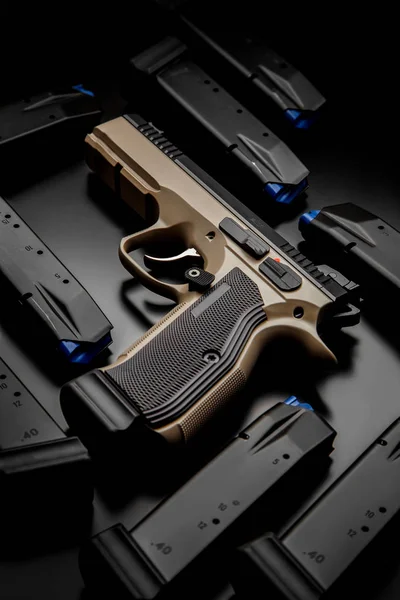 Modern zwartbruin pistool op een donkere achtergrond. Reclame foto o — Stockfoto