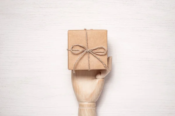 Mannequin en bois main ouvre un cadeau dans une boîte attachée avec ficelle. Gif ! — Photo