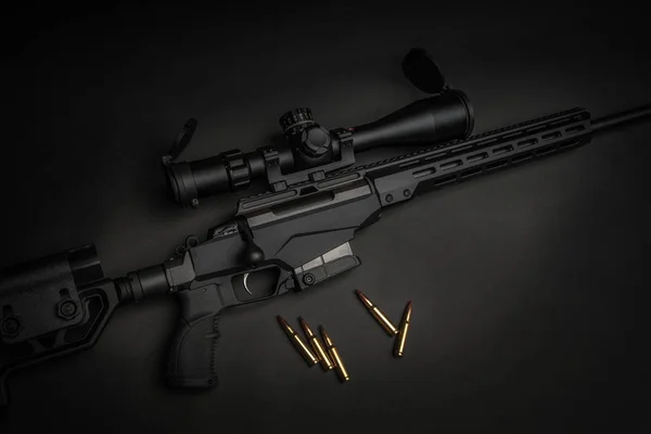 Moderno fucile da cecchino su sfondo scuro. Cartucce vicino a un taglio — Foto Stock