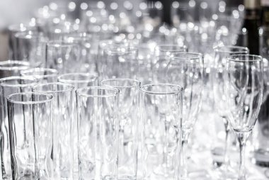 Masada bir sürü farklı boş bardak var. Ziyafet, tatil ya da düğün hazırlığı. Bulanık arkaplan.