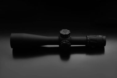 Karanlık bir arka planda modern bir keskin nişancı dürbünü. Uzun mesafelerde nişan almak ve ateş etmek için optik aygıt.