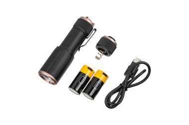 Küçük siyah ve bakır bir el feneri pilleri ve şarj kablosuyla parçalanmış..