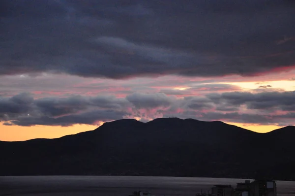Schwarze Hügel Bei Sonnenuntergang Mit Bunten Wolken Und Goldenen Spiegelungen — Stockfoto