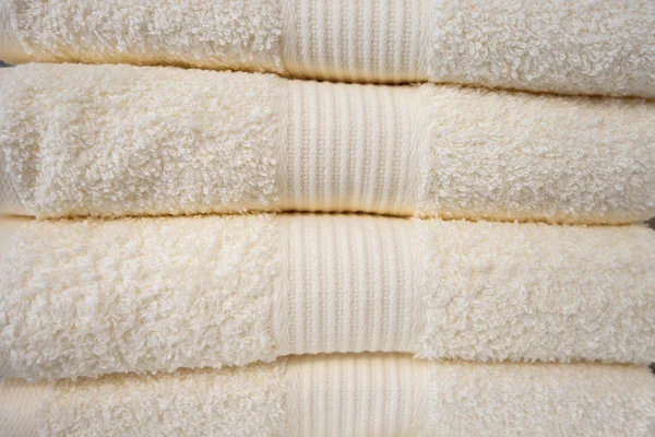 Clean towels. Many clean white towels are neatly stacked on the shelf.