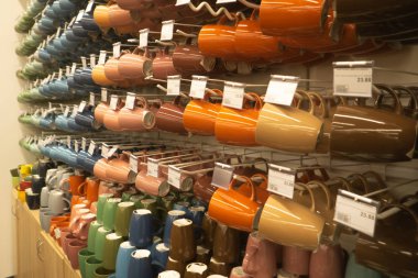 Parlak turuncu ve beyaz yemekleri, tabak ve bardak beyaz rafta duran. Satın alma yeni seçme kavramı iç kapalı dekorasyon o hediyeler için ev, ev yemekleri. Temiz sıralı yemekleri deposunda. Bulaşıkları yıkamalı - bardak, tabak, kase cerami arka plan