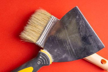 Metal spatula, mala ile Plastik Saplı ve copyspase beyaz zemin üzerine iki boya fırçası. Fırça ve spatula - bej ve parlak kırmızı turuncu mor zemin üstüne boya araçları görüntülemek.