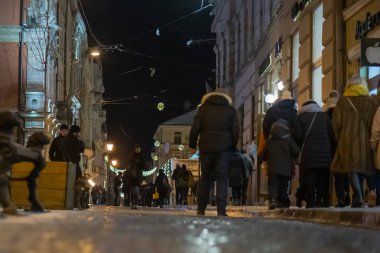 Islak erimiş buz kaldırımda yürümek. Arkadan görünüm buzlu kaldırım yürüyen bir adam ayakları üzerinde. Kışın buzlu yolda Ayakkabı çifti. Soyut boş boş kış hava arka plan. Gece şehrin turistler kaldırımda kaygan buz üzerinde yürümek.