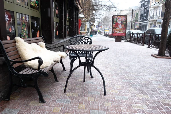 Coffee table, bench and an outdoor chair. Snowing