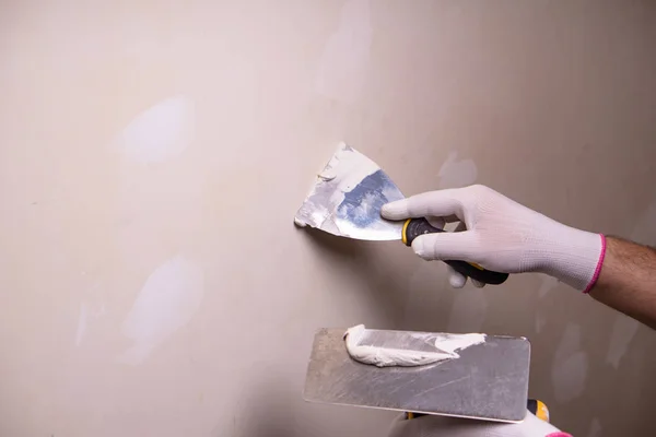El, macun bıçağı onarım duvarı, el, spatula, spatula, spatula macun yapısı, macun macunu katmanı uygulama süreci, alçı macunu ile çalışma..