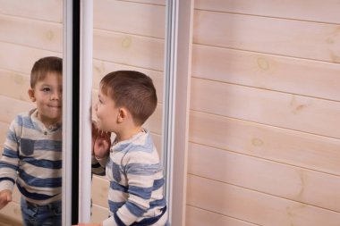 Üç yaşında beyaz bir arka plan üzerinde kamera önünde poz bir çocuk