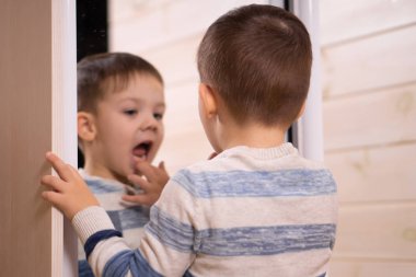 Üç yaşında beyaz bir arka plan üzerinde kamera önünde poz bir çocuk