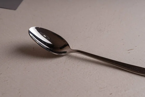 A teaspoon of shiny stainless lies on the table — Stock Photo, Image