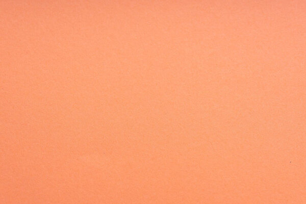 Paper background coral color. Rough paper texture. Closeup. Macro.