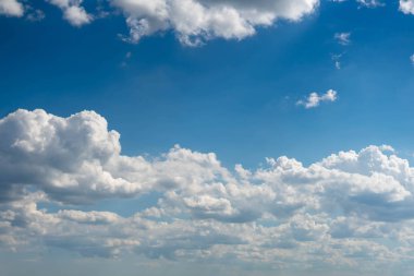 Beyaz bulutlar ve ince bir ufuk çizgisi ile güzel mavi gökyüzü. Işınlar Güneş bulutların arasından kırılır