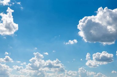 Beyaz bulutlar ve ince bir ufuk çizgisi ile güzel mavi gökyüzü. Işınlar Güneş bulutların arasından kırılır