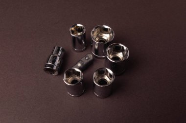 Kahverengi arka plan üzerinde farklı boyutlardaki vidaları sıkmak için bit bitleri.