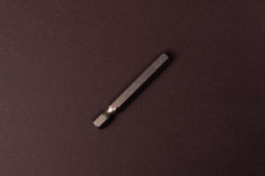 Kahverengi arka plan üzerinde farklı boyutlardaki vidaları sıkmak için bit bitleri.