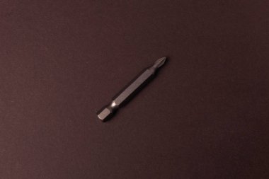 Kahverengi arka plan üzerinde farklı boyutlardaki vidaları sıkmak için bit bitleri.