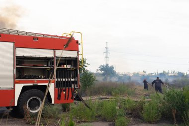Yangın motorunda bir itfaiye, bir orman ateşi söndürür. Rus-itfaiye arabası ve Odessa arabada yazıtlar. 2019.06. 08. Odessa 'da. Ukrayna.