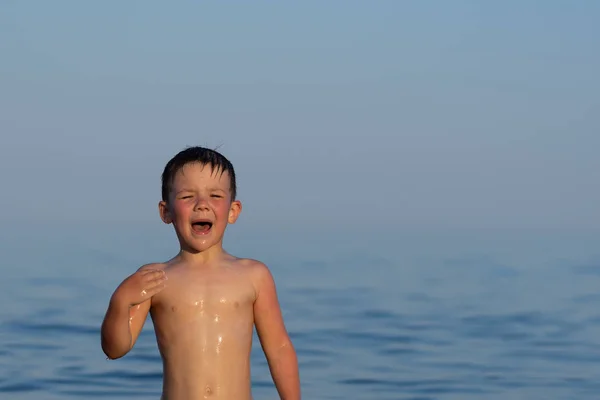 Chłopiec z trzech lat jest pływanie w morzu o zachodzie słońca z bratem. — Zdjęcie stockowe