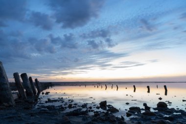 Kuyalnik liman 'da gün batımı. Odessa. Ukrayna. Eski günlükleri su görülebilir-antik bir iskelenin kalıntıları.