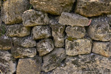 Eski taş duvar yosun ile kaplıdır. Doğal bir taş. Vintage yaratıcı arka plan.