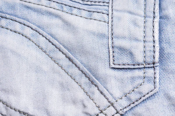 Denim azul. Tecido de algodão, jeans. Fundo vintage criativo. Bolso e fecho. A linha é de má qualidade. Item barato . — Fotografia de Stock