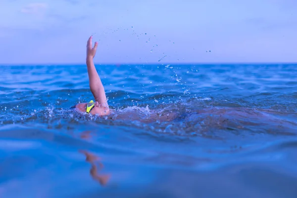 Ένα 10-χρονο αγόρι κολυμπάει στη θάλασσα την αυγή με ποτήρια για κολύμπι — Φωτογραφία Αρχείου