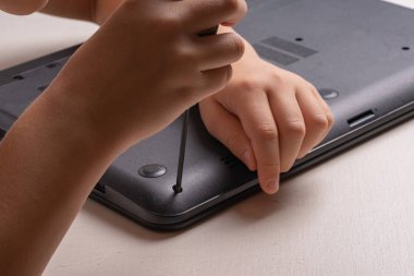 10 yaşında bir çocuk temizlik ve bakım için bir laptop sıralama