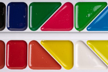 Bir okul setinde çok renkli suluboya boyalar bir palet.