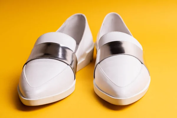White women\'s low-heeled shoes with a silver stripe on a yellow