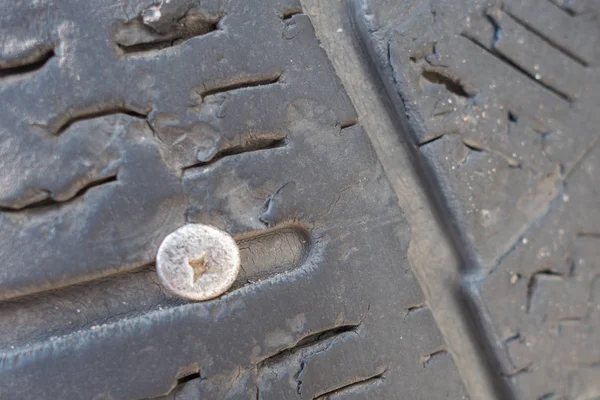 Negl eller skrue i en bil hjul. Punkteret dæk. Uforudsete situationer - Stock-foto