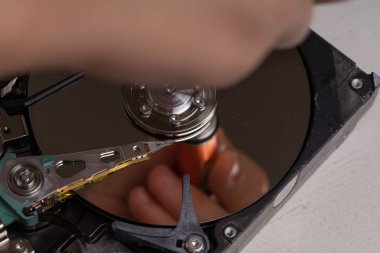 Bir genç, bir bilgisayarın sabit diskini incelemek için söker.