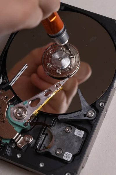 Een tiener disassembleert de harde schijf van een computer om het te bestuderen — Stockfoto