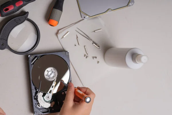 Een tiener disassembleert de harde schijf van een computer om het te bestuderen — Stockfoto