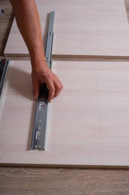 Ahşap yonga mobilyalarını monte eden bir zanaatkarın elleri..