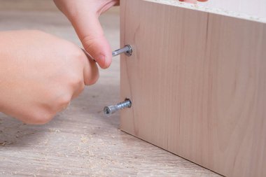 Ahşap yonga mobilyalarını monte eden bir zanaatkarın elleri. Sıkı tut.