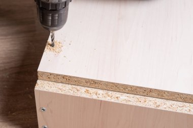 Ahşap yonga mobilyalarını monte eden bir zanaatkarın elleri..