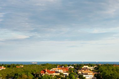 Denizin üzerinde güzel dramatik bulutlar. Deniz kıyısındaki evlerin çatıları.