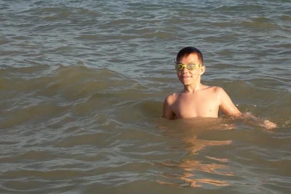 10歳の男の子は海の海岸の波で泳ぐことを楽しんでいます 水泳の結果に満足している — ストック写真