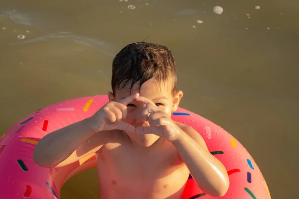 Pięcioletni Chłopiec Pływa Bawi Się Morzu Nad Brzegiem Nadmuchiwanym Kółkiem — Zdjęcie stockowe