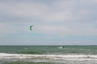 Büyük bir şehrin arka planına karşı denizde birkaç yelkenli Kate sörfçüsü. Odessa 'da. Ukrayna. 20.05.24.