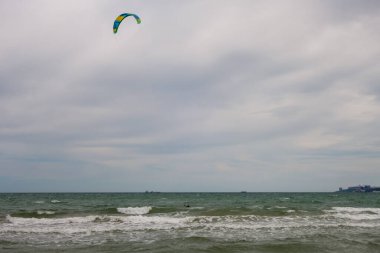 Büyük bir şehrin arka planına karşı denizde birkaç yelkenli Kate sörfçüsü. Odessa 'da. Ukrayna. 20.05.24.