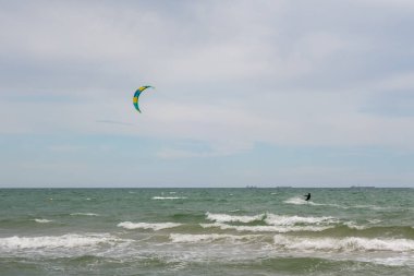 Büyük bir şehrin arka planına karşı denizde birkaç yelkenli Kate sörfçüsü. Odessa 'da. Ukrayna. 20.05.24.